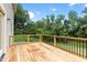 Wooden deck and black railing. The view beyond the railing is green foliage and blue skies at 200 Single Tree Cir, Haw River, NC 27258