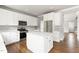 Modern kitchen with white cabinets, stainless steel appliances, an island, and hardwood floors at 200 Single Tree Cir, Haw River, NC 27258