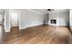 Open-concept living room featuring hardwood floors, a cozy fireplace, and neutral wall paint at 200 Single Tree Cir, Haw River, NC 27258