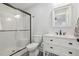 A full bath with a glass enclosed shower and a white marble topped vanity at 212 Lynch Ave, Lillington, NC 27546