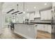 Modern kitchen featuring white cabinets, black countertops, stainless steel appliances, and a breakfast bar at 212 Lynch Ave, Lillington, NC 27546