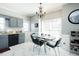 Eat-in kitchen boasts grey cabinets, marble flooring, and stylish black dining set illuminated by a modern chandelier at 2203 Eider Ct # A, Graham, NC 27253