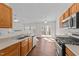 Kitchen with stainless steel appliances and wood cabinets overlooking living area at 224 Hartshorn Ct, Holly Springs, NC 27540