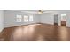 Spacious living room features a ceiling fan, three windows, and doorway to the bathroom at 224 Hartshorn Ct, Holly Springs, NC 27540