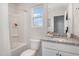 Bright bathroom featuring granite countertop, sleek white cabinetry, and tub with shower at 260 Johnson Ridge Way, Four Oaks, NC 27524