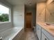 Bright bathroom with double vanity, soaking tub and walk-in closet at 260 Johnson Ridge Way, Four Oaks, NC 27524