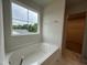 Modern bathroom featuring a soaking tub with a large window view at 260 Johnson Ridge Way, Four Oaks, NC 27524