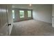 Spacious bedroom with plush carpeting and ample natural light from three windows at 260 Johnson Ridge Way, Four Oaks, NC 27524