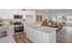 Modern kitchen with a granite countertop island, stainless appliances, and ample storage space at 260 Johnson Ridge Way, Four Oaks, NC 27524