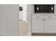 Butler's pantry area features white cabinets, dark backsplash, and hardwood flooring at 267 N Maple Walk Dr # 217, Garner, NC 27529