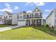 Beautiful gray two-story home featuring manicured lawn, a two-car garage, and a classic covered front porch at 267 N Maple Walk Dr # 217, Garner, NC 27529