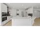 Modern kitchen with white cabinets, quartz countertops, and a black backsplash at 267 N Maple Walk Dr # 217, Garner, NC 27529