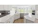 Bright kitchen showcasing white cabinets, a farmhouse sink, a stainless steel dishwasher, and modern finishes at 267 N Maple Walk Dr # 217, Garner, NC 27529