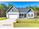 Charming single-story home boasts a two-car garage, beautiful landscaping, and a welcoming front porch at 27 Mossman Ct, Zebulon, NC 27597