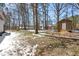 Backyard view featuring trees and a shed on a partially snow covered lawn at 316 Russ Rd, Smithfield, NC 27577