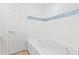 A bathtub with white tile surround and decorative blue tile accent at 316 Russ Rd, Smithfield, NC 27577