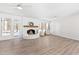 Bright living room featuring a white brick fireplace, wood floors, and large windows at 316 Russ Rd, Smithfield, NC 27577