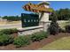 The 'Larue' community entrance sign is beautifully landscaped with mulch and green bushes at 326 Church St # 42, Wendell, NC 27591