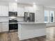Modern kitchen island with granite countertops, stainless steel appliances and white cabinetry at 326 Church St # 42, Wendell, NC 27591