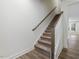 Carpeted staircase with wood banister offers a seamless transition between floors in a modern home at 326 Church St # 42, Wendell, NC 27591