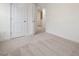 A bright bedroom with neutral carpet and trim and an open door to the hallway at 330 Church St # 44, Wendell, NC 27591
