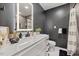 Modern bathroom featuring a marble countertop, illuminated mirror, sleek fixtures, and tiled shower at 3506 Bellevue Rd, Raleigh, NC 27609