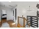 Hallway with hardwood floors, modern railing, and a contemporary chandelier at 3506 Bellevue Rd, Raleigh, NC 27609
