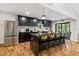 Bright kitchen with black cabinets, stainless steel appliances, marble counters, and a large island with bar stool seating at 3506 Bellevue Rd, Raleigh, NC 27609