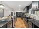 Long kitchen with black cabinets and black marble counter tops, stainless steel oven, stove top and stainless steel refrigerator at 3506 Bellevue Rd, Raleigh, NC 27609