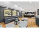 Open-concept living room with hardwood floors, modern decor, and a view of the black kitchen with bar seating at 3506 Bellevue Rd, Raleigh, NC 27609