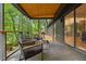 Covered outdoor patio featuring stylish chairs, glass-panel door, and serene wooded views, ideal for relaxation at 3506 Bellevue Rd, Raleigh, NC 27609
