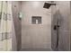 Walk-in shower with gray tile, rainfall showerhead, and built-in niche for toiletries at 3506 Bellevue Rd, Raleigh, NC 27609