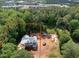 An aerial view of a new home build marked with property lines, surrounded by a green forest and some buildings at 3601 Alamance Dr, Raleigh, NC 27609
