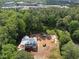 Aerial view of a new home construction site nestled among dense trees and nearby buildings at 3601 Alamance Dr, Raleigh, NC 27609