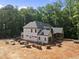 Aerial view captures the home's exterior with its elegant roofline amidst a backdrop of lush trees at 3601 Alamance Dr, Raleigh, NC 27609
