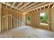 Wood framing of a new room shows the placement of windows and a view of the tree-filled landscape outside at 3601 Alamance Dr, Raleigh, NC 27609