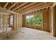 The wood framing is complete, awaiting walls, and the large picture window frames the green trees outside at 3601 Alamance Dr, Raleigh, NC 27609