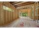 Unfinished interior featuring wood framing, natural light, and potential layout options at 3601 Alamance Dr, Raleigh, NC 27609