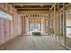 Unfinished living room with windows, wood framing, and pink insulation at 3601 Alamance Dr, Raleigh, NC 27609