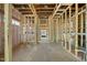 View of the unfinished living room showing wood framing, insulation, and electrical wiring at 3601 Alamance Dr, Raleigh, NC 27609