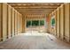 Open-concept living room featuring unfinished walls with views of the backyard and natural light at 3601 Alamance Dr, Raleigh, NC 27609