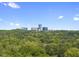 Skyline view showcasing modern buildings, surrounded by lush greenery, under a clear blue sky at 3601 Alamance Dr, Raleigh, NC 27609