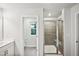 Bright bathroom featuring a glass shower with tiled surround, toilet, vanity, and window at 4108 Shadbush St, Raleigh, NC 27616