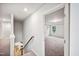 Bright hallway featuring staircase, wood flooring, and an open doorway to a carpeted room with tray ceilings at 4108 Shadbush St, Raleigh, NC 27616