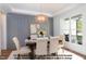 Dining room featuring a rectangular table, upholstered chairs, wainscotting, and natural light from a large window at 4622 Durham Rd, Wake Forest, NC 27587