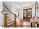 Inviting entryway featuring a wooden staircase, hardwood floors, and a view of the front door and living area at 4622 Durham Rd, Wake Forest, NC 27587
