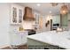 Bright kitchen featuring white cabinets, white tile backsplash, a copper hood, and an island with a white countertop at 4622 Durham Rd, Wake Forest, NC 27587