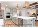 Beautiful kitchen featuring light green cabinets, an island with white countertop, and decorative hanging lights at 4622 Durham Rd, Wake Forest, NC 27587