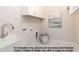 Bright laundry room with white cabinets, stainless steel faucet, and marble-patterned tile flooring at 4622 Durham Rd, Wake Forest, NC 27587