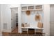 Functional mudroom with built-in bench, storage shelves, coat hooks, and a door leading to a pantry at 4622 Durham Rd, Wake Forest, NC 27587